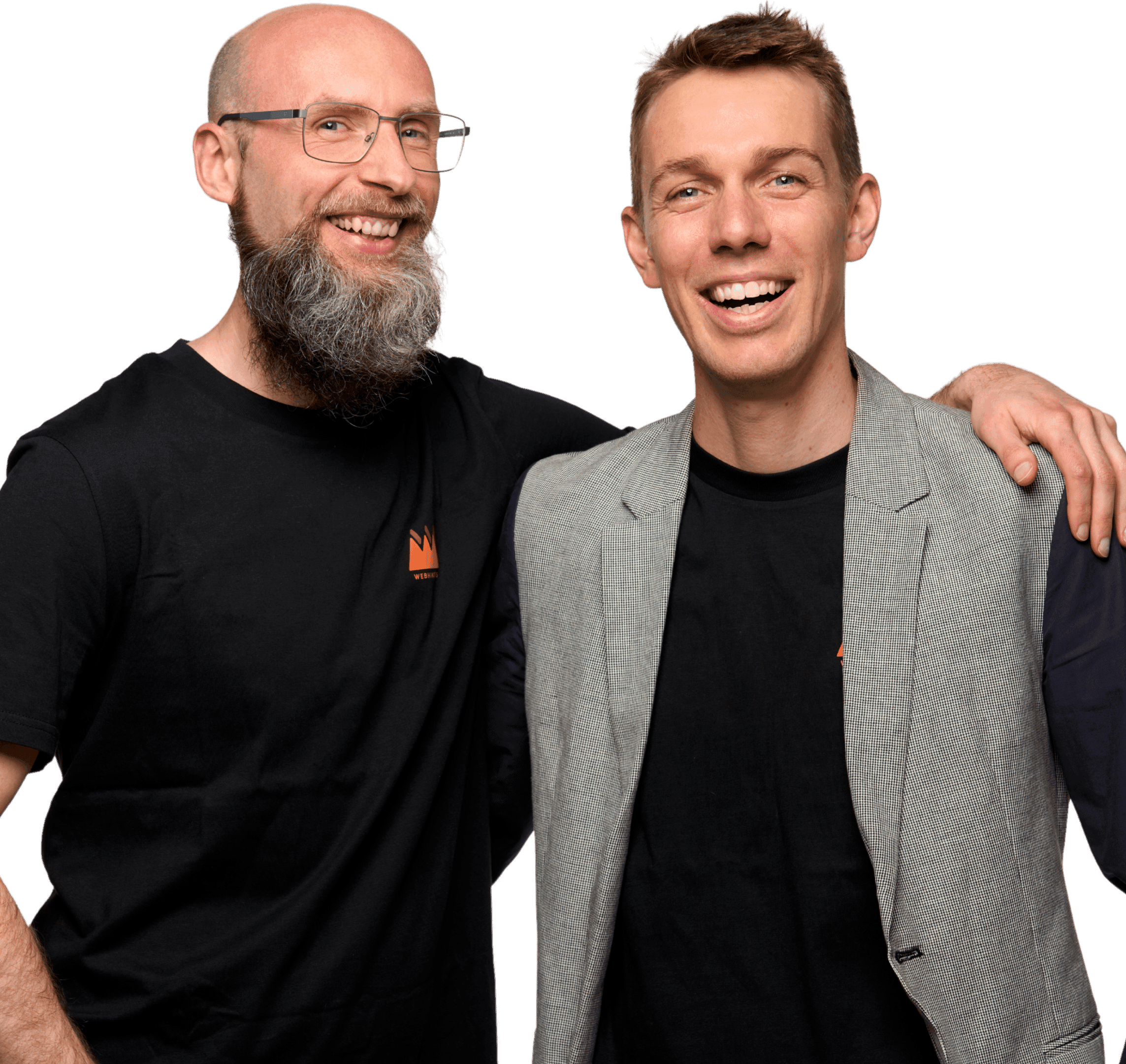 Zwei lächelnde Männer des Webhikers-Teams, einer mit Bart und Brille im schwarzen T-Shirt, der andere im grauen Sakko